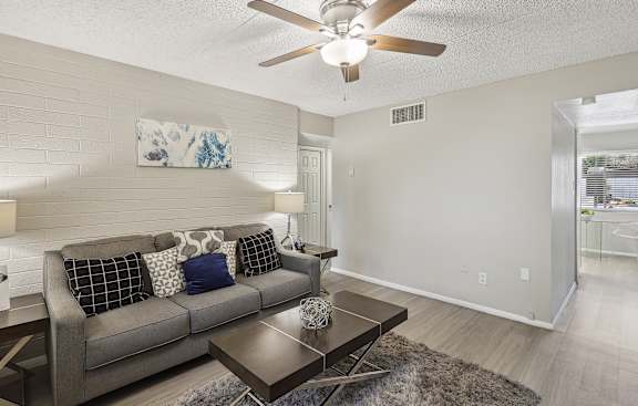 a living room with a couch and a ceiling fan