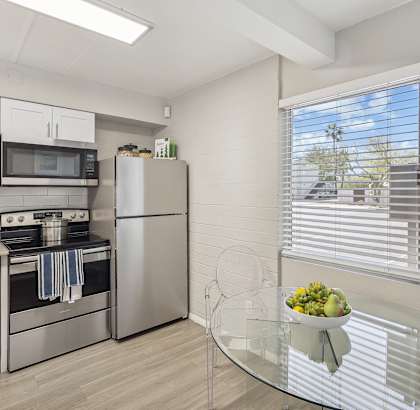 a kitchen with stainless steel appliances and a glass table