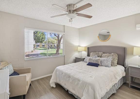 a bedroom with a large bed and a ceiling fan