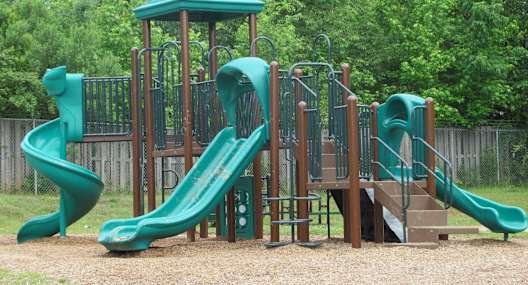 a playground with two slides and a playset