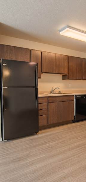 A kitchen with black appliances and wooden cabinets.