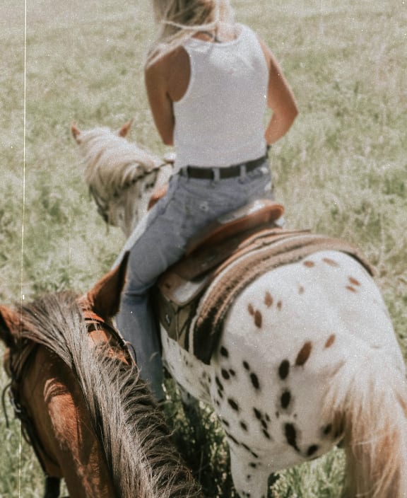 a woman riding on the back of a horse
