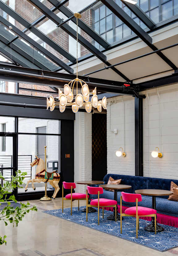 A chandelier with white globes hangs from a ceiling with a decorative mural.