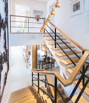 A staircase with a black metal railing and wooden steps.