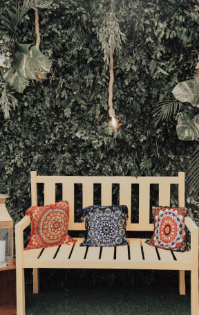 a wooden bench with two pillows on it
