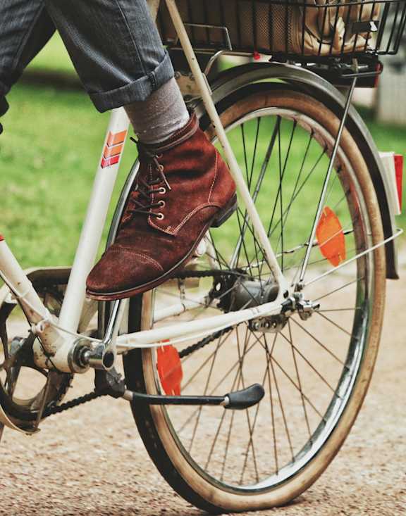 A person is riding a bicycle with a basket on the back.