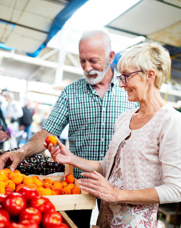 a person buying vegetables at a grocery store