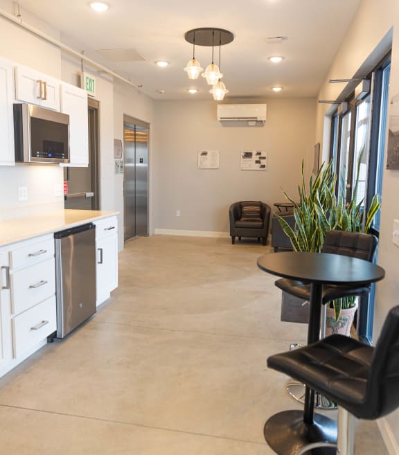 a kitchen and living room with a black table and chairs
