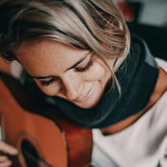 A woman playing a guitar.