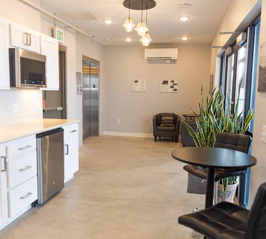 a kitchen and living room with a black table and chairs