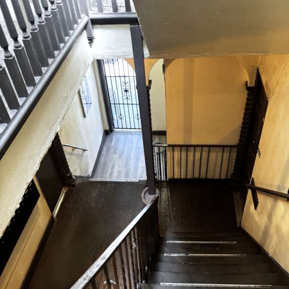 A staircase with a metal railing and wooden steps.