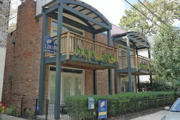 a building with a balcony and a car parked in front of it