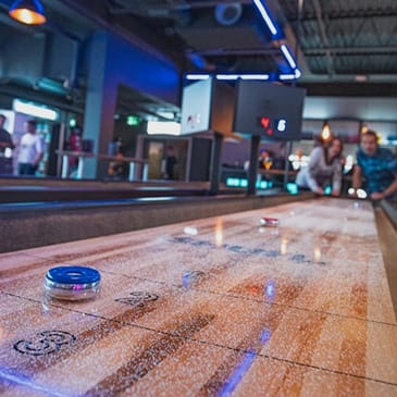 people playing a game of bowling at a bowling alley
