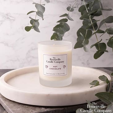 a white candle sitting on top of a white plate