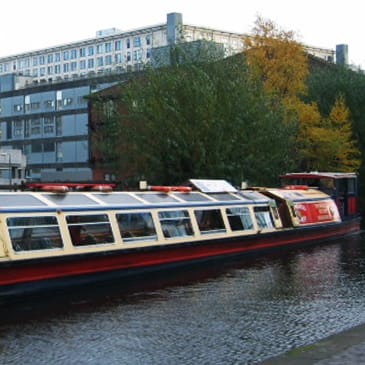a boat on a river with buildings in the background