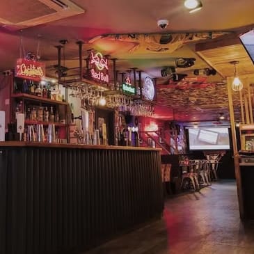 a bar in a restaurant with a lot of liquor on the walls and a ceiling