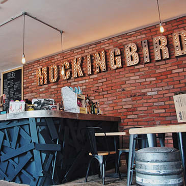 a brick wall with a bar and a sign on it that reads rocking bird bar