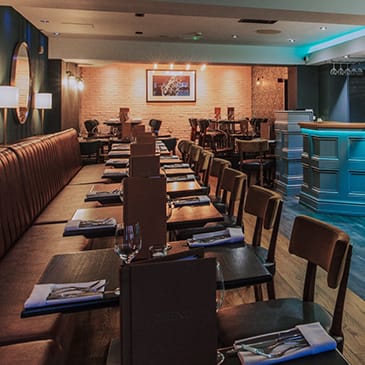 a dining room with tables and chairs and a bar
