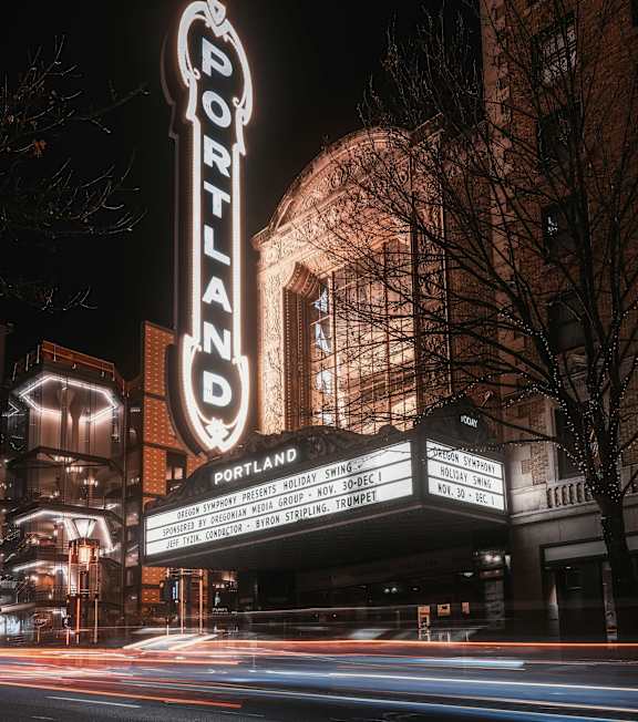 A brightly lit Portland sign is seen at night.