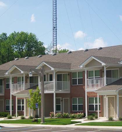 Apartment building with a tree in front of it.
