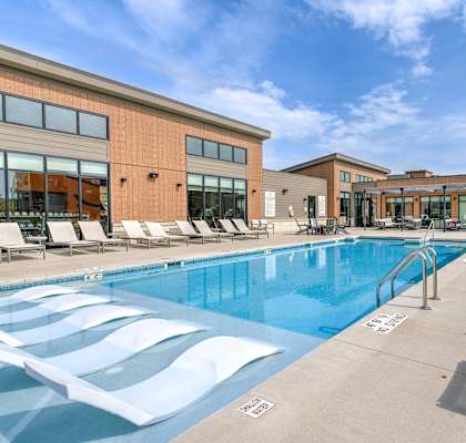 a swimming pool in front of a building at Statesman Apartments, Franklin, WI 53132