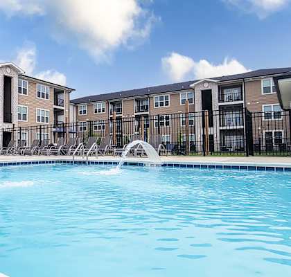 A large swimming pool in front of apartment buildings.