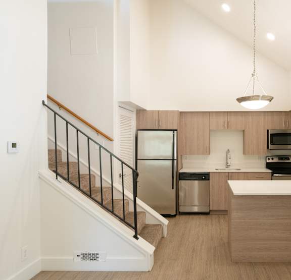 a kitchen with a white counter top and a stainless steel refrigerator