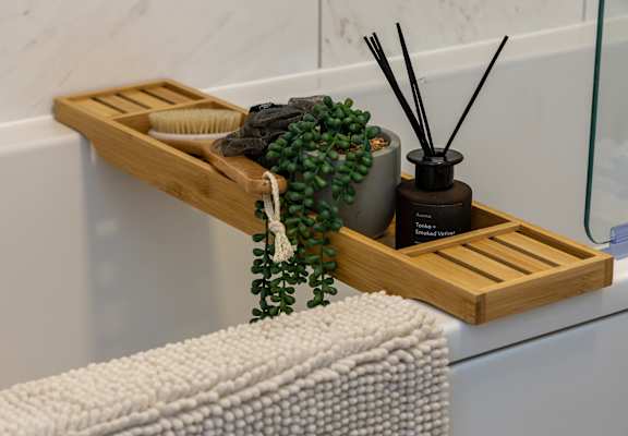 a wooden shelf with a plant on a bathroom sink