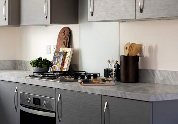 a kitchen with a stove and a cutting board on the counter