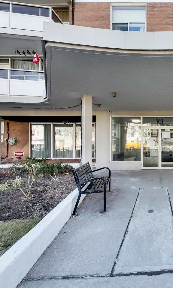 A building with a white overhang and two black benches in front.