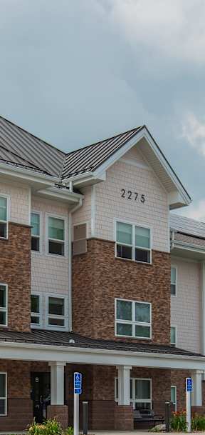 A large apartment complex with a parking lot in front.