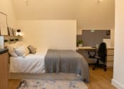 Thumbnail 8 of 8 - a bedroom with a bed and a desk with a chair