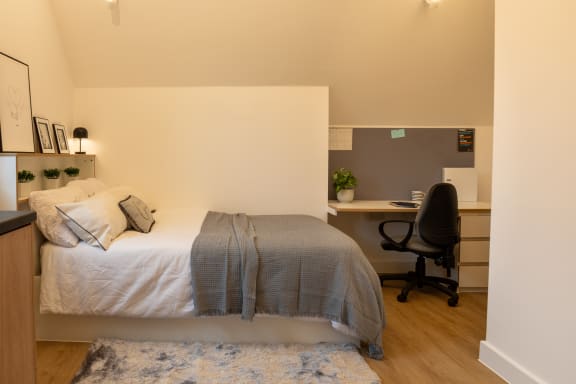 a bedroom with a bed and a desk with a chair