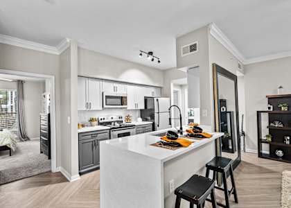 A modern kitchen with a large island and stools.