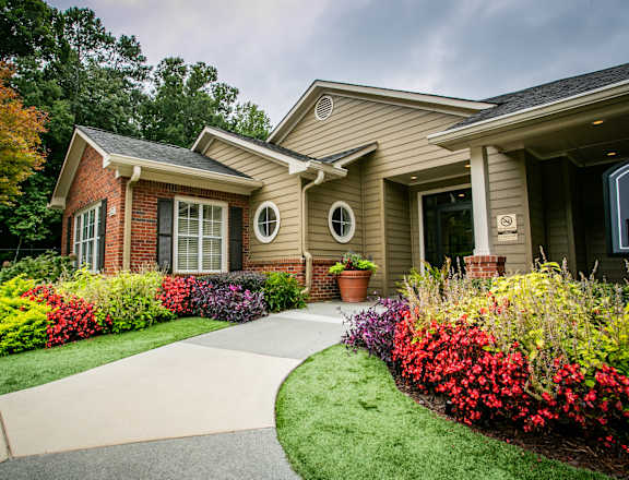 a house with a sidewalk in front of it and a garden