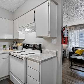 A kitchen with white cabinets and a black stove top oven.