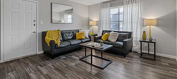 A living room with a black couch and a coffee table.