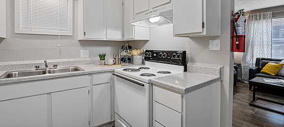 A kitchen with white cabinets and a black stove top oven.