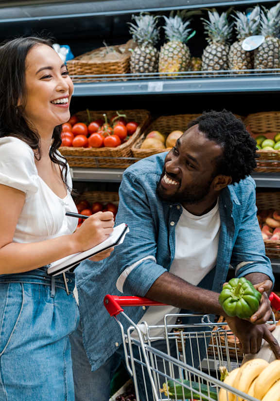 A man and a woman are shopping together in a grocery store.