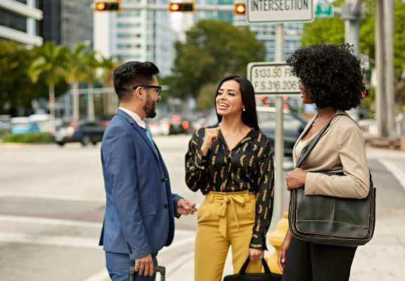 people standing on a street corner with luggage