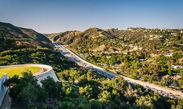 an aerial view of a highway in the mountains
