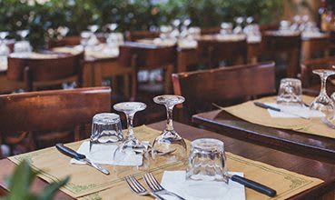 a restaurant with tables and chairs and wine glasses