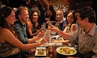 a group of people sitting around a table drinking wine