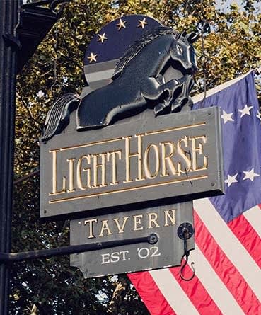 a sign for the light horse tavern with an flag at The Enclave, Jersey City, New Jersey
