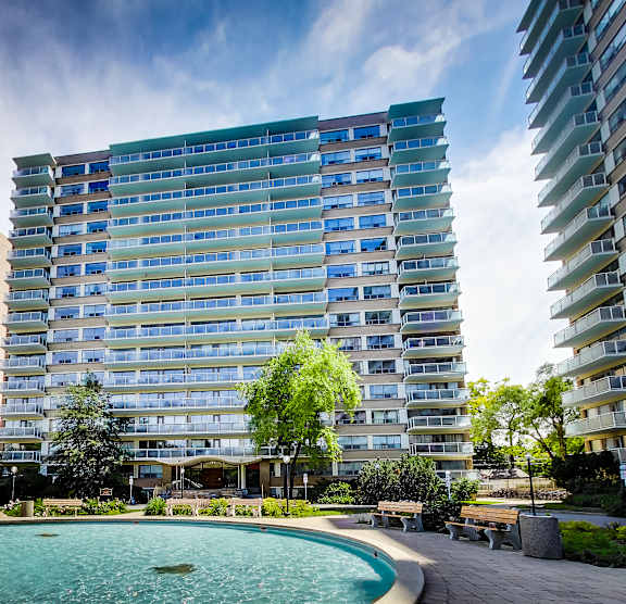 A large building with a pool in front of it.