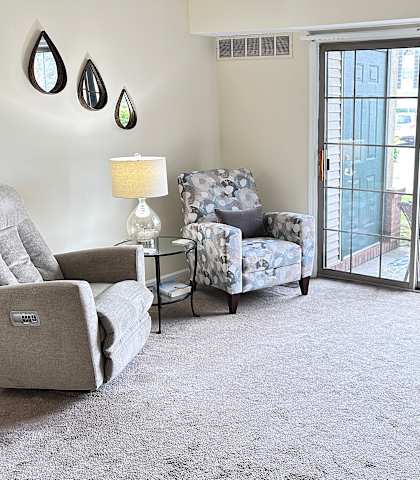 a living room with two chairs and a sliding glass door