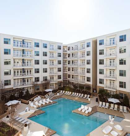 an overhead view of a large swimming pool in front of an apartment building