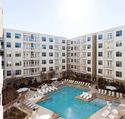 an overhead view of a large swimming pool in front of an apartment building
