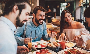 a group of people sitting at a table eating food