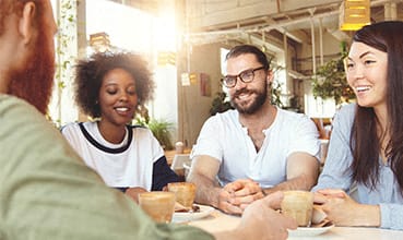 a group of people sitting at a table talking